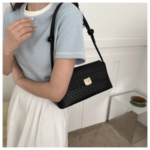 Quilted black baguette shoulder bag with gold clasp and knot detail on the strap