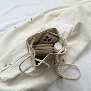 Fashionable woven bucket bag with drawstring closure showing large interior capacity