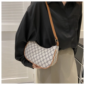 Vintage hobo shoulder bag with retro geometric pattern and brown leather trim on a model