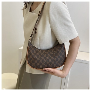 Detail of vintage crescent shoulder bag with dark brown pattern and leather trim