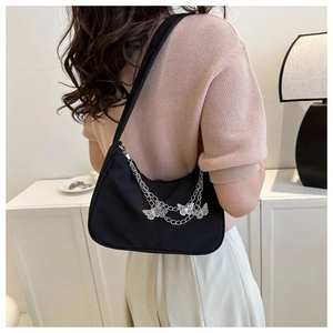 Detail of black nylon hobo bag with silver butterfly chains worn on shoulder