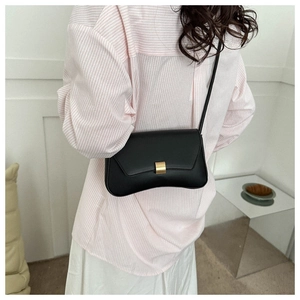 Detailed view of a sleek black matte leather shoulder bag with a gold buckle and strap