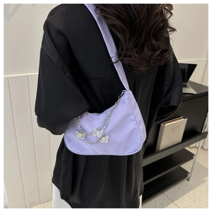 Detail of light purple shoulder bag featuring Y2K silver chains and butterfly charms