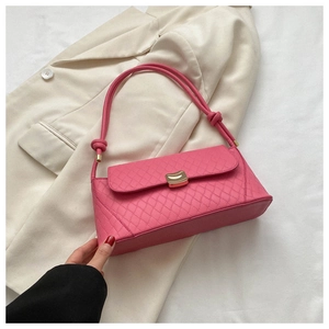 Detail of pink quilted shoulder bag with gold metal clasp and knot strap decor