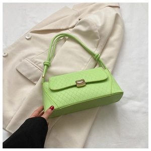 Close-up of lime green quilted baguette bag with gold buckle and knotted strap detail