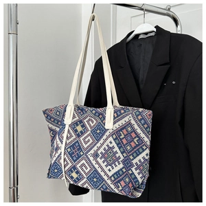 Detail of ethnic geometric jacquard woven tote bag with durable white leather handles