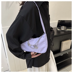Detail of lavender nylon shoulder bag with silver double metal chains and butterfly charms