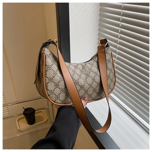 Detail of vintage crescent bag featuring classic floral pattern and brown faux leather strap