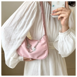 Pink underarm bag detail featuring silver butterfly chains and Y2K nylon texture