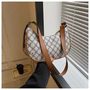 Detail of vintage hobo bag featuring clover patterns and premium brown leather strap