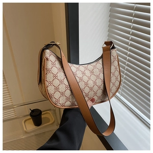 Detail of retro crescent bag showing clover jacquard pattern and tan leather strap