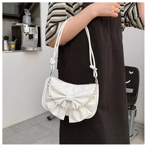 Detail of white bow shoulder bag featuring pearl chain and thick rope strap on model