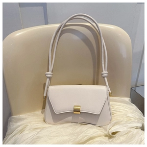 Detail of white baguette bag with golden metal clasp and delicate shoulder strap knot