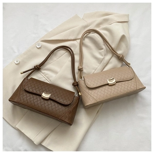 Detail of quilted leather baguette bags with gold metal clasps and knotted shoulder straps