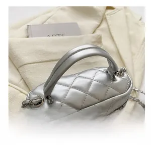 Close-up of silver quilted box bag featuring dual zippers and metallic chain strap