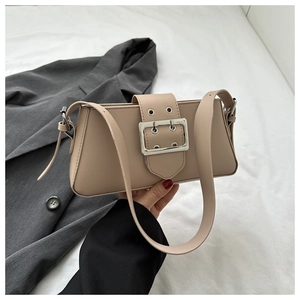 Close-up of beige leather shoulder bag featuring a prominent silver square buckle and strap
