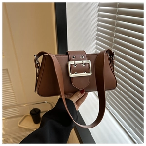 Detail of vintage brown leather underarm bag featuring a large silver metal buckle strap