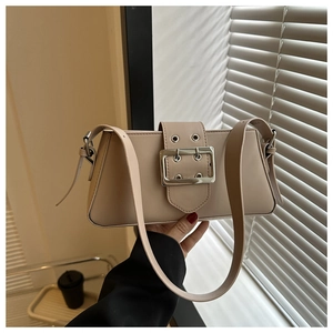 Detail of minimalist beige underarm bag with signature oversized silver metal buckle