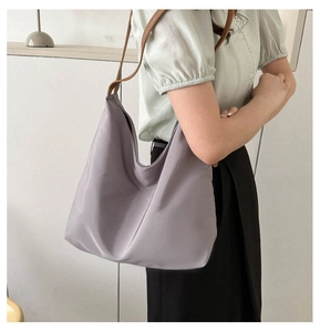 Macro shot of large mauve canvas tote bag with brown leather shoulder straps