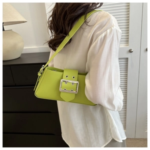 Close-up of vibrant neon green shoulder bag featuring a large silver metallic buckle