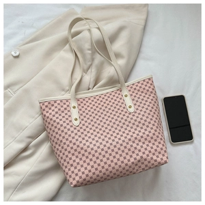 Detailed view of pink tote bag with geometric pattern and ivory leather handles