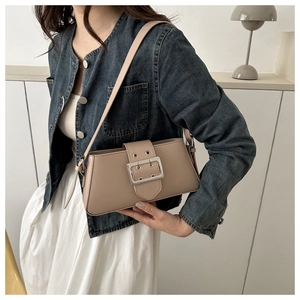 Detail of minimalist beige underarm bag with silver buckle and sleek leather finish