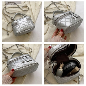 Detail of silver quilted box bag with floral accent and interior storage capacity