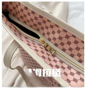 Detail of premium pink tote bag with floral patterns and a smooth gold zipper closure