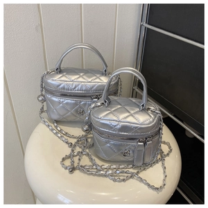 Detail view of silver quilted mini box bags featuring metallic chain straps and flower zippers