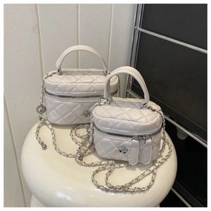 Detailed view of white quilted mini crossbody bag with silver camellia floral accent