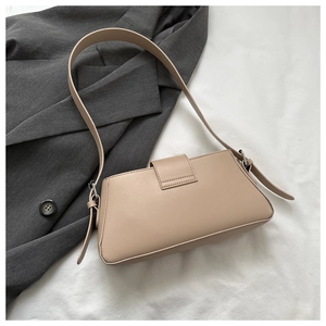 Detail of beige rectangular underarm bag showing adjustable silver buckle on a shoulder strap