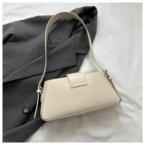 Close-up of minimalist cream white baguette underarm bag with silver metallic buckle detail