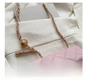 Detail der rosa gesteppten Ledertasche mit verstellbarer Goldkugel und Metallkette
