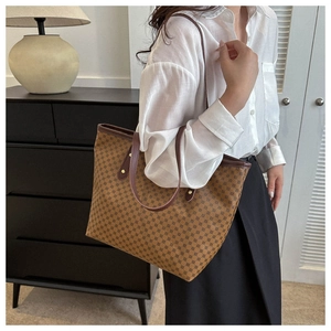 Close-up of brown tote bag with geometric dot patterns and premium leather handles