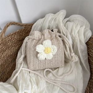 Handmade woven bucket bag with large floral detail and crossbody rope shoulder strap