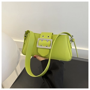 Detail of green baguette shoulder bag featuring a large silver buckle and eyelet strap