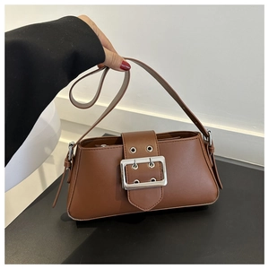 Detail of a brown shoulder bag with a large silver square buckle and wide strap