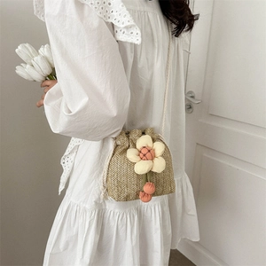 Mini straw bucket bag for women with decorative fabric flower and drawstring closure