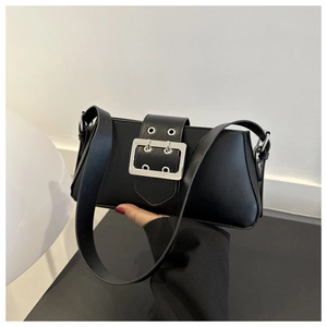 Detail of black leather underarm bag with oversized silver buckle and punk metal eyelets