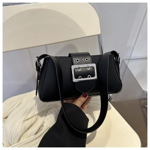 Detail of black matte leather shoulder bag featuring a silver square buckle and eyelets