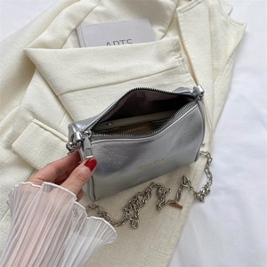 Silver metallic chain crossbody bag with Only Bug logo on chic cream blazer background