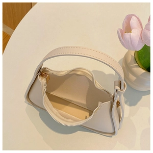 Vista dettagliata dall'alto di una borsa minimalista in pelle PU crema con cerniera lampo