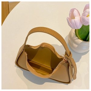Dettaglio della borsa sottobraccio kaki con cerniera dorata e interno spazioso ed elegante