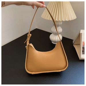 Dettaglio borsa sottobraccio in ecopelle color cammello con tracolla regolabile e fibbia