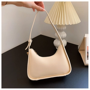 Dettaglio della borsa a mezzaluna beige minimalista in pelle sintetica liscia