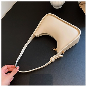 Dettaglio borsa hobo bianco crema con fibbia dorata e tracolla sottile regolabile