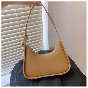 Dettaglio della borsa hobo a mezzaluna color caramello con tracolla regolabile e zip metallica
