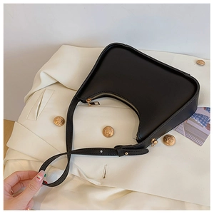 Dettaglio di una borsa a mezzaluna nera opaca con tracolla regolabile in pelle abbinata