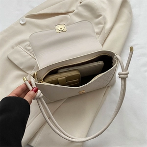 Chic beige woven shoulder bag with tie-knot strap showcasing interior capacity for daily use
