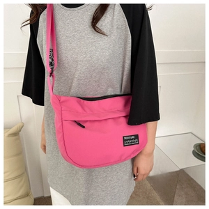 Dettaglio borsa a tracolla in nylon rosa con tasca frontale e tracolla regolabile